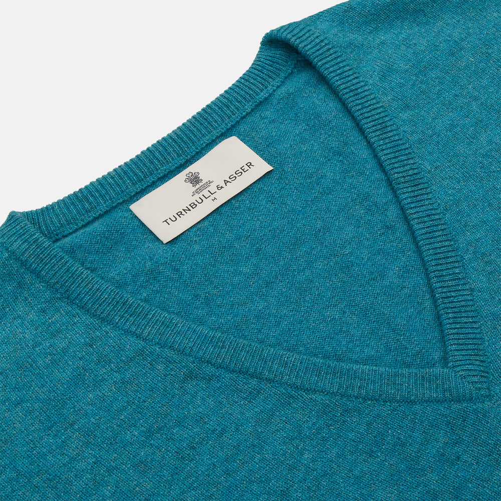 The Teal Ifor Slipover by Turnbull & Asser is a sleeveless, V-neck knit made in Scotland from lightweight cashmere, shown in teal blue against a white background.