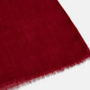 View 2 of product The Burgundy Cashmere Scarf by Turnbull & Asser features a soft texture, deep red hue, and lightly frayed edges, loosely knotted and displayed on a plain white background—an elegant luxury accessory.