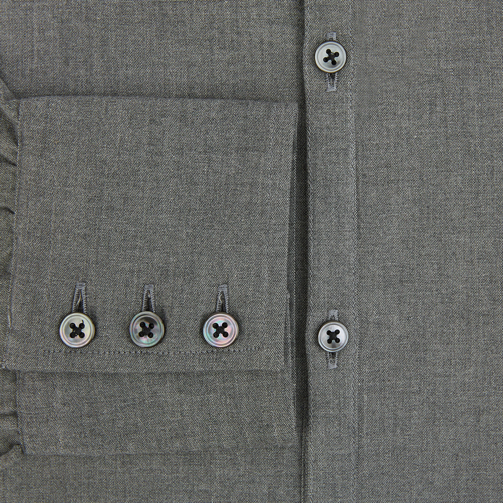 The Pale Charcoal Westminster Shirt by Turnbull & Asser features British craftsmanship with a tailored silhouette, long sleeves, pointed collar, buttoned cuffs, and a solid pale charcoal hue, elegantly shown against a white background.