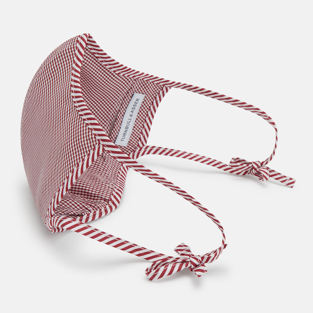 The Turnbull & Asser Burgundy Check Commuter Mask comes with 3 Viroformula™ filters. It features a check pattern, adjustable ear straps, and is displayed on a plain white background.