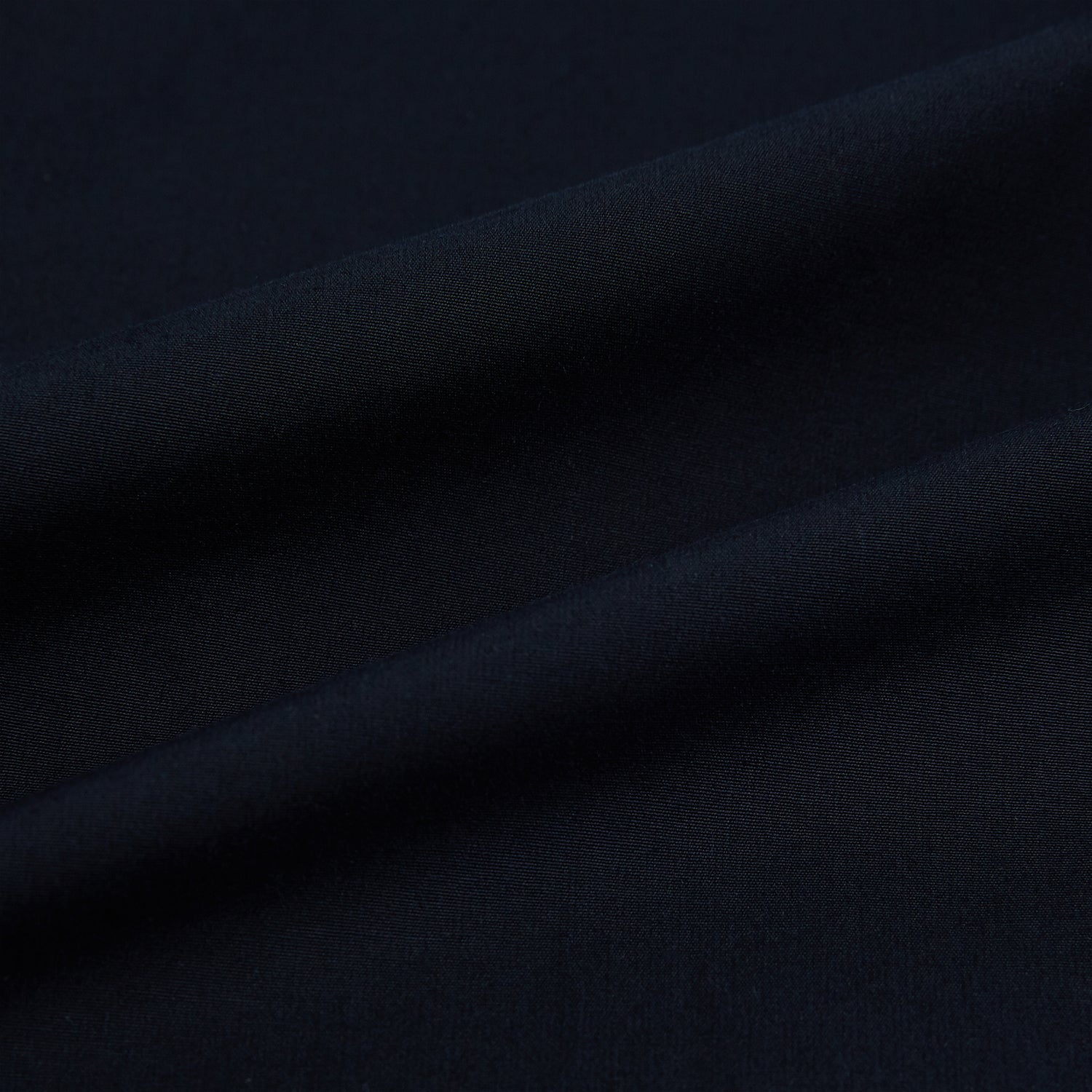 View 8 of product The NAVY BLUE WINDSOR SHIRT by Turnbull & Asser features long sleeves, a classic Windsor collar, white buttons, and buttoned cuffs—highlighting refined British craftsmanship against a plain white background.