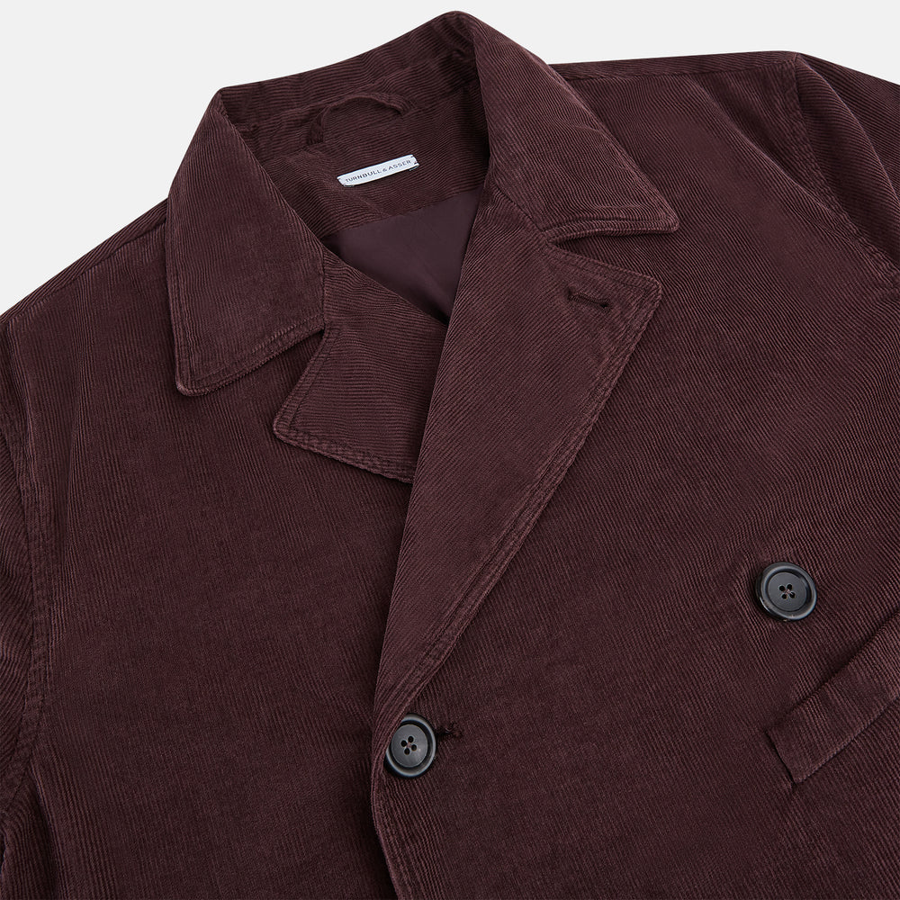 The Burgundy Kingston Corduroy Caban Jacket by Turnbull & Asser features black buttons, a notched collar, and front pockets. Crafted from premium cotton, it is shown on a plain white background.