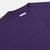View 2 of product The Turnbull & Asser Purple Cashmere Round Neck Jumper features long sleeves, ribbed cuffs, hem, and collar for an elegant silhouette. This versatile knitwear piece is shown against a white background.