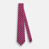 View 2 of product The Turnbull & Asser Purple Motif Silk Tie, rolled up and displayed on a light gray background, features small blue and white geometric designs—an elegant British touch for any formal event.