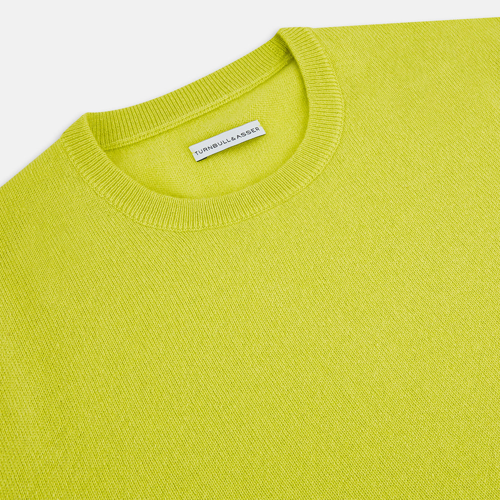 The Turnbull & Asser Lemon Green Cashmere Round Neck Jumper features long sleeves with ribbed cuffs and hem, displayed on a white background.