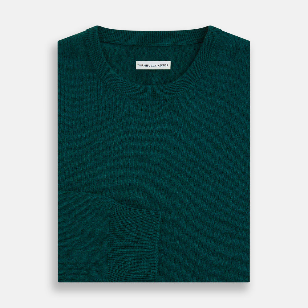 The Turnbull & Asser Moss Green Cashmere Round Neck Jumper, shown on a plain white background, is men's knitwear with long sleeves and a classic design featuring ribbed cuffs, neckline, and hem for timeless style.