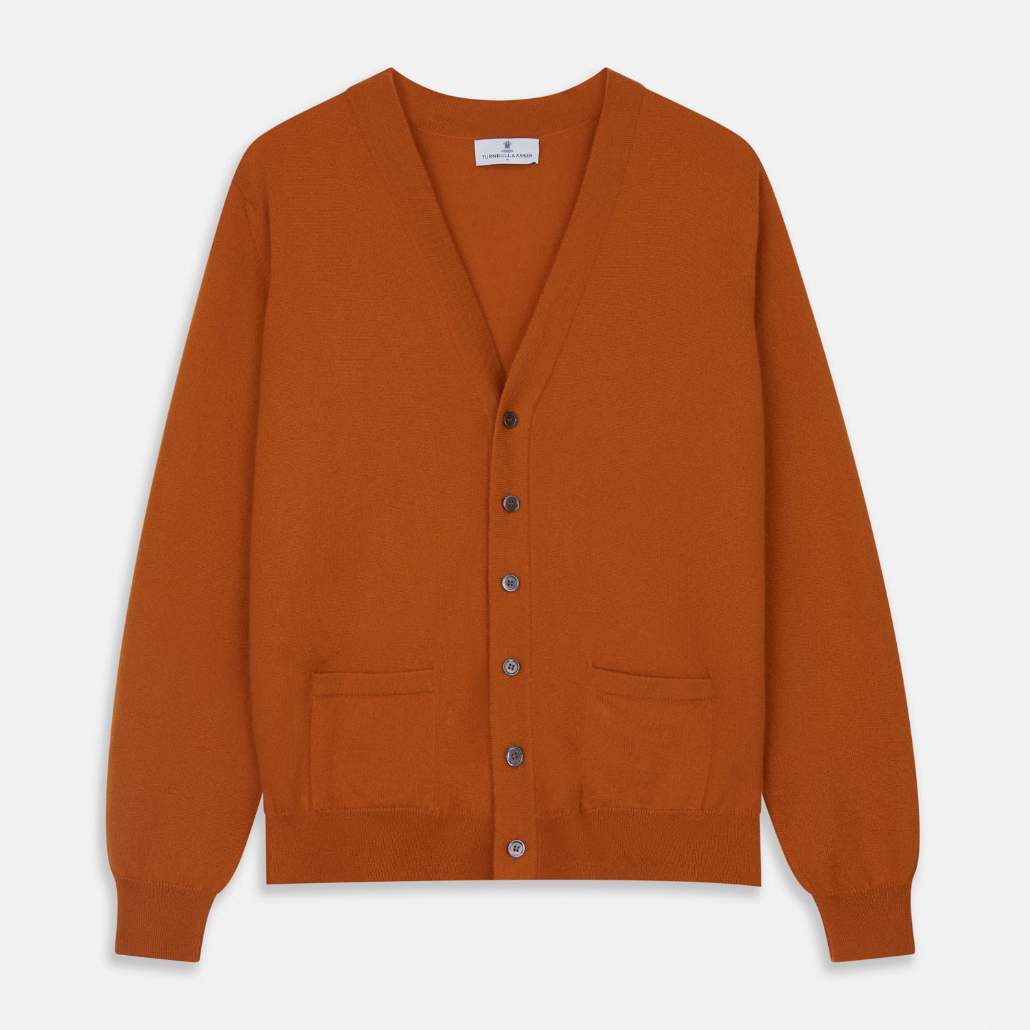 View 1 of product The Rust Lachlan Cashmere Cardigan by Turnbull & Asser features a V-neck, long sleeves, front button closure, and two front pockets—ideal for layering in smart-casual looks. Shown laid flat on a plain white background.