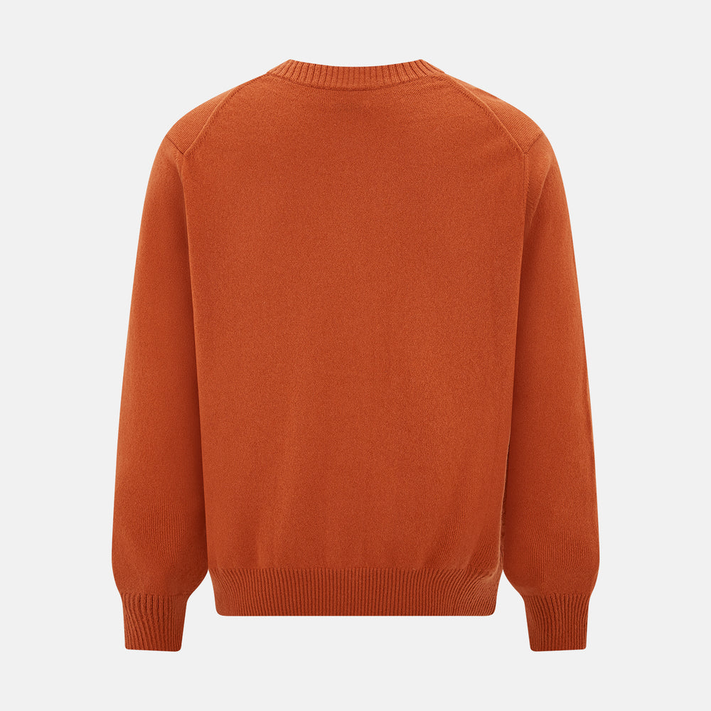 The Orange Cashmere Cardigan by Turnbull & Asser showcases vibrant burnt orange, a V-neck, dark buttons, ribbed cuffs and hem, long sleeves, and two front pockets. Part of the knitwear collection; displayed on a white background.