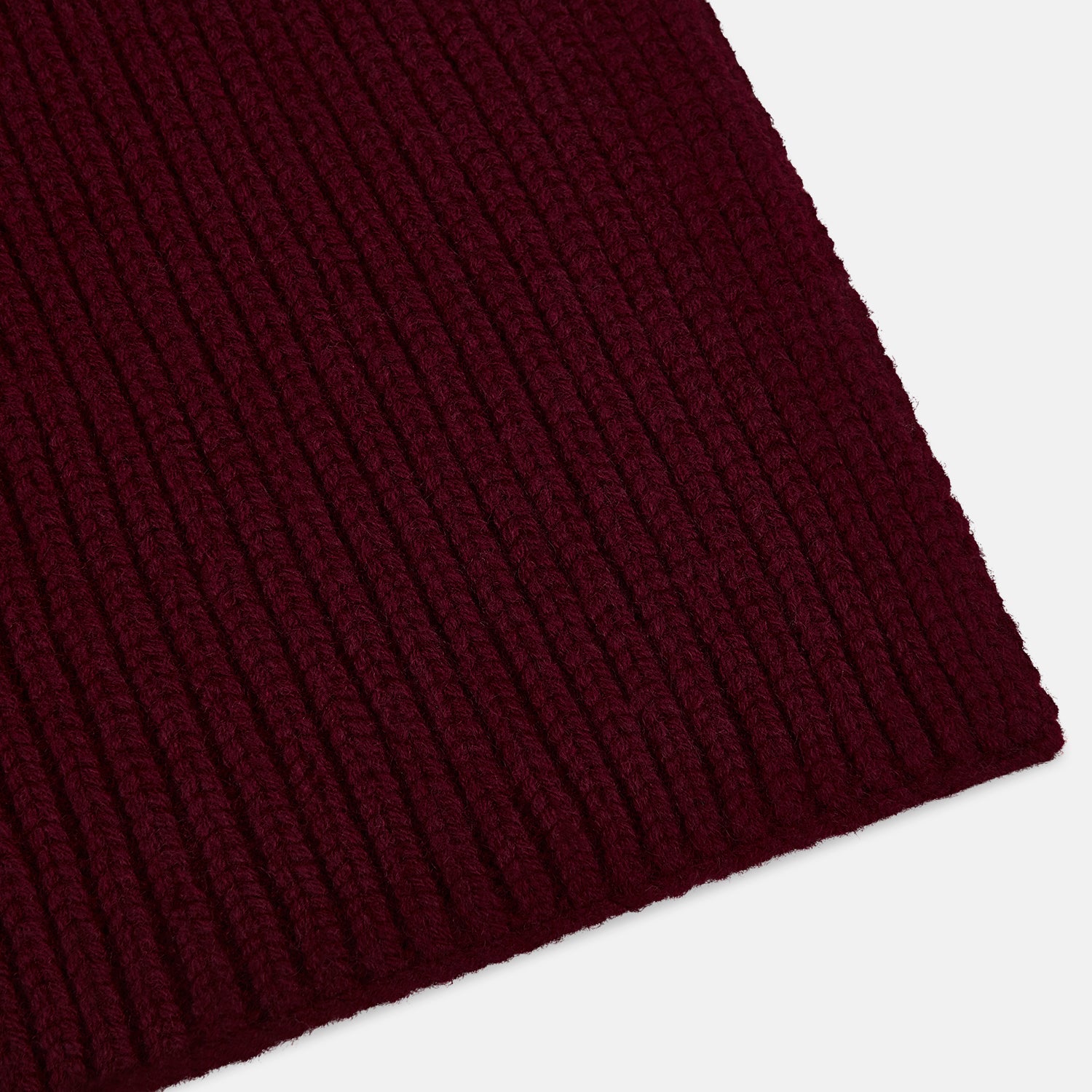 Image 2 of product The Burgundy Rib-Knit Cashmere Scarf by Turnbull & Asser is crossed at the center and set against a plain light gray background—an elegant, luxurious winter accessory.