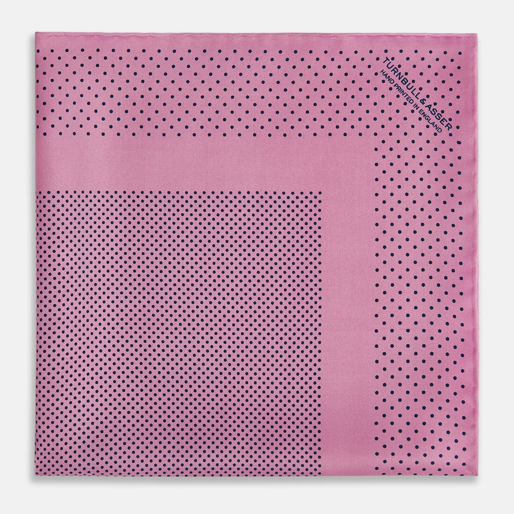The Pink Dot Silk Pocket Square by Turnbull & Asser features pink silk with a border of small black dots, expertly handcrafted for a stylish touch to any suit. Fold to showcase both sides for added elegance.