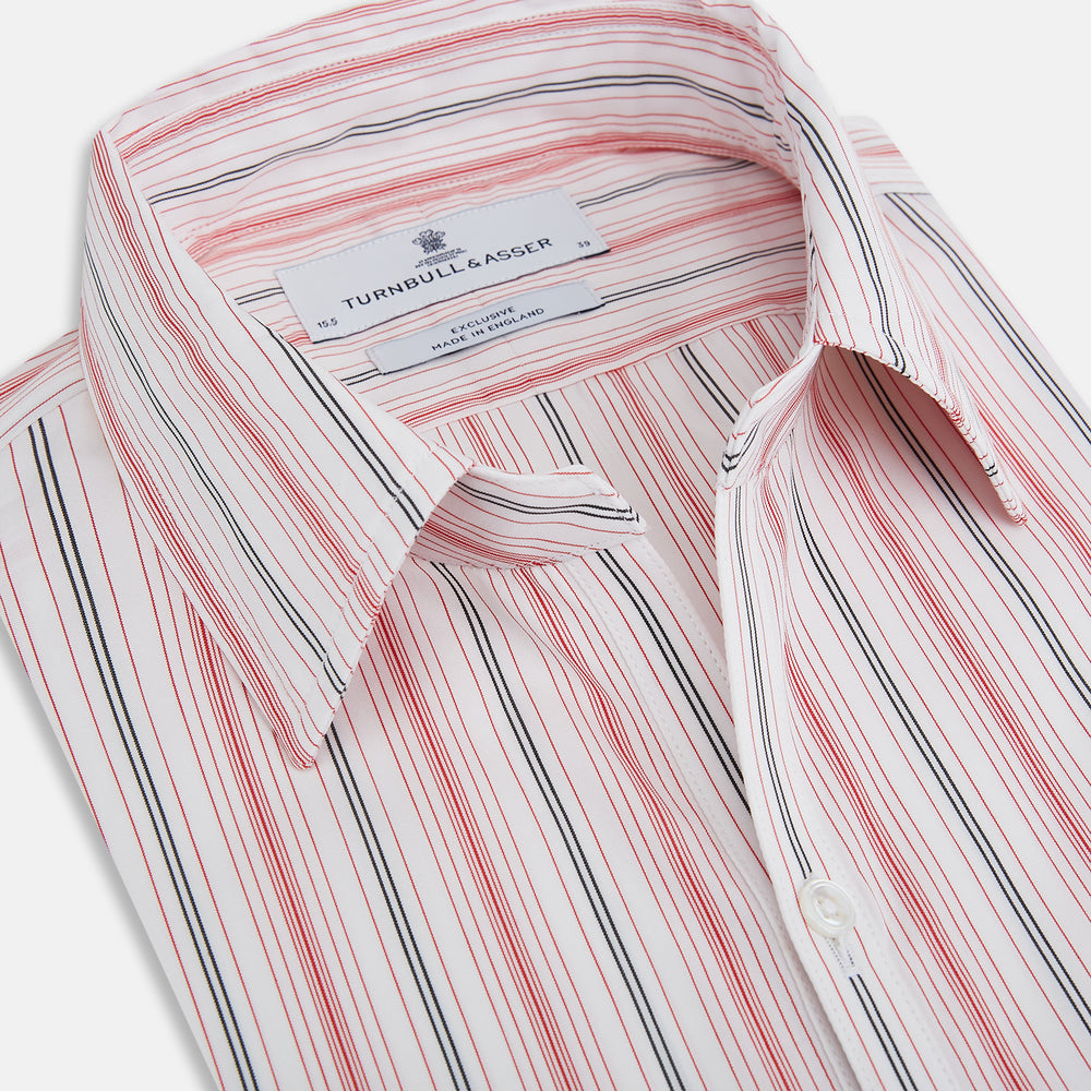 The Red Multi Pencil Stripe Windsor Shirt by Turnbull & Asser features long sleeves, buttoned cuffs, a Turnbull collar, and classic British tailoring with vertical red, pink, and white stripes.