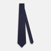 View 2 of product The Turnbull & Asser Navy and Grey Circle Silk Tie, featuring a refined pattern of evenly spaced circles, is elegantly displayed rolled up on a white background—an excellent option for modern office wear.