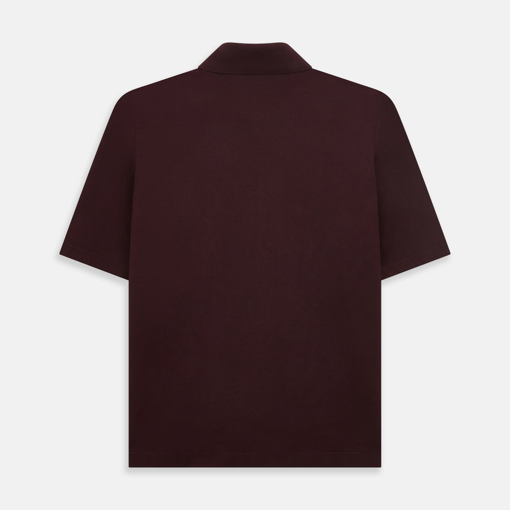 The Turnbull & Asser Burgundy Polo Shirt is crafted from soft cotton jersey with short sleeves, a classic collar, three front buttons, and a small buttoned chest pocket, shown flat on a white background.