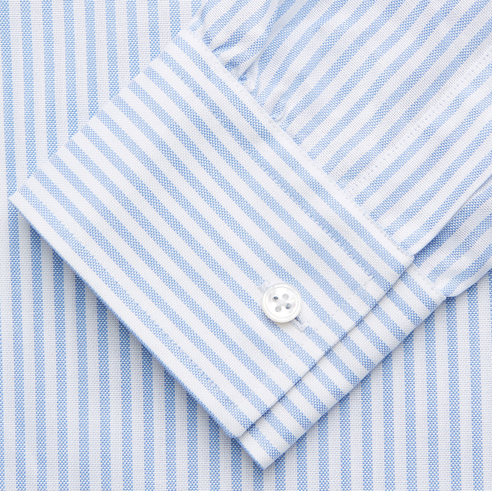 The Turnbull & Asser Pale Blue Stripe Weekend Fit Hayne Shirt features a Dorset collar, 1-button cuffs, and vertical stripes, shown laid flat against a white background.