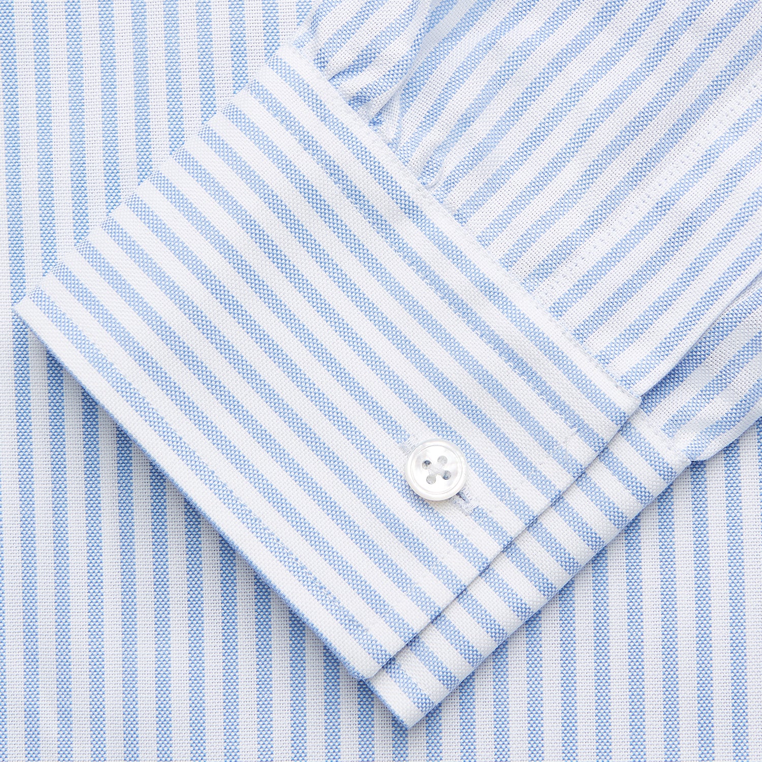 View 4 of product The Turnbull & Asser Pale Blue Stripe Weekend Fit Hayne Shirt features a Dorset collar, 1-button cuffs, and vertical stripes, shown laid flat against a white background.