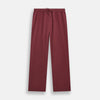 View 6 of product The Turnbull & Asser Burgundy Silk Pyjama Set features a long-sleeve, button-up shirt with chest pocket and matching pants with elastic waistband and side pocket, shown on a white background.