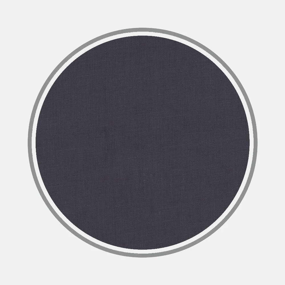 A dark gray textured fabric circle, inspired by bespoke shirt materials and monograms, is centered on light gray with two thin concentric rings. Featured: Bespoke Fabric 1292 05 by Turnbull & Asser.