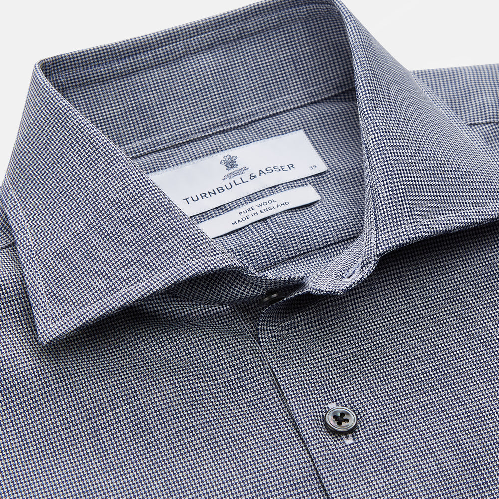 The Turnbull & Asser Navy Houndstooth Wool Tailored Fit Shelton Shirt features a classic collar, buttoned cuffs, and a refined tailored fit, shown laid flat on a white background.