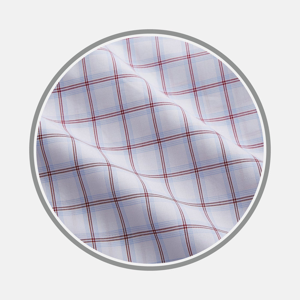 NEW BESPOKE FABRIC 1327 34 by Turnbull & Asser: White fabric with a red and blue plaid design, shown in a circular frame. Perfect for bespoke or custom shirts, the material features intersecting lines forming squares and a slightly wrinkled texture.