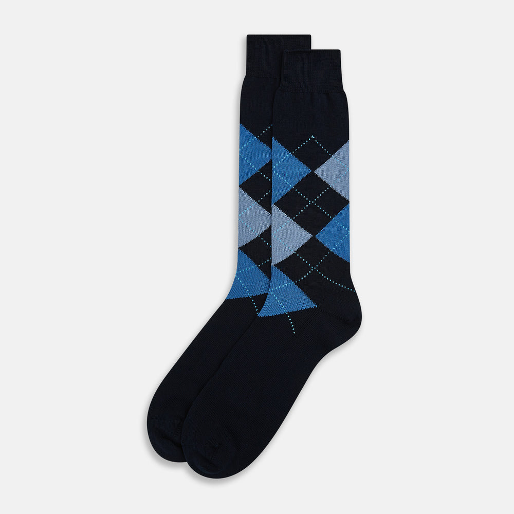 The Turnbull & Asser Navy Check Mid-Length Sock, crafted from ultra-soft cotton, features a blue and light blue argyle pattern with diamond shapes and dotted lines, and is showcased against a plain white background.