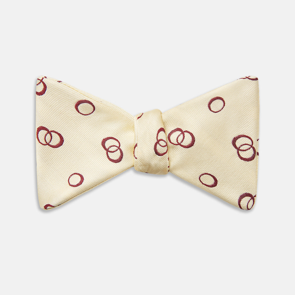 The Yellow Geometric Rings Silk Bow Tie by Turnbull & Asser features interlocking rings in a bold geometric pattern, crafted from silk.