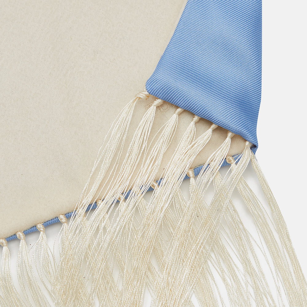 The Turnbull & Asser GGSC3128 5665 06 OS is a blue paisley silk scarf with ornate gold designs, solid light blue ends, and cream fringes. Shown laid flat with one end folded, it highlights its luxurious style.