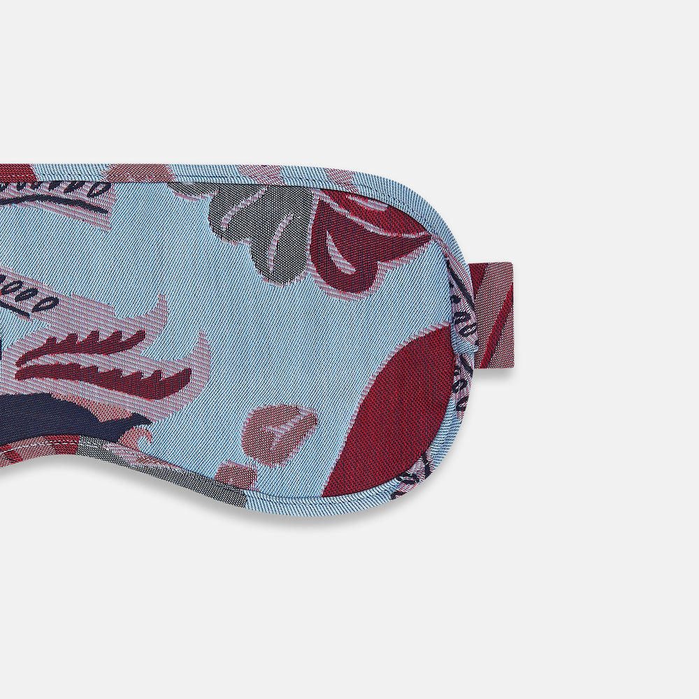 The Blue Bloomsbury Jacquard Cashmere Lined Sleep Mask and Bag by Turnbull & Asser features a blue and red abstract floral pattern, elastic strap, and is shown on a plain white background.