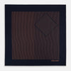 View 3 of product The Turnbull & Asser Navy and Blush Stripe Silk Pocket Square features thin blush stripes on navy silk, finished with "TURNBULL & ASSER HAND PRINTED IN ENGLAND" in the corner, highlighting its refined English craftsmanship.