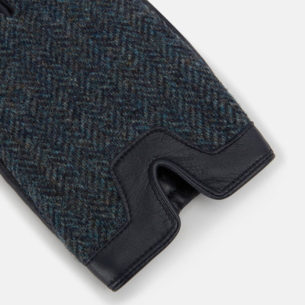 Turnbull & Asser Navy Herringbone Tweed Cashmere-Lined Leather Gloves are shown on a white background: one glove features dark navy herringbone tweed, the other shows a smooth black leather palm.