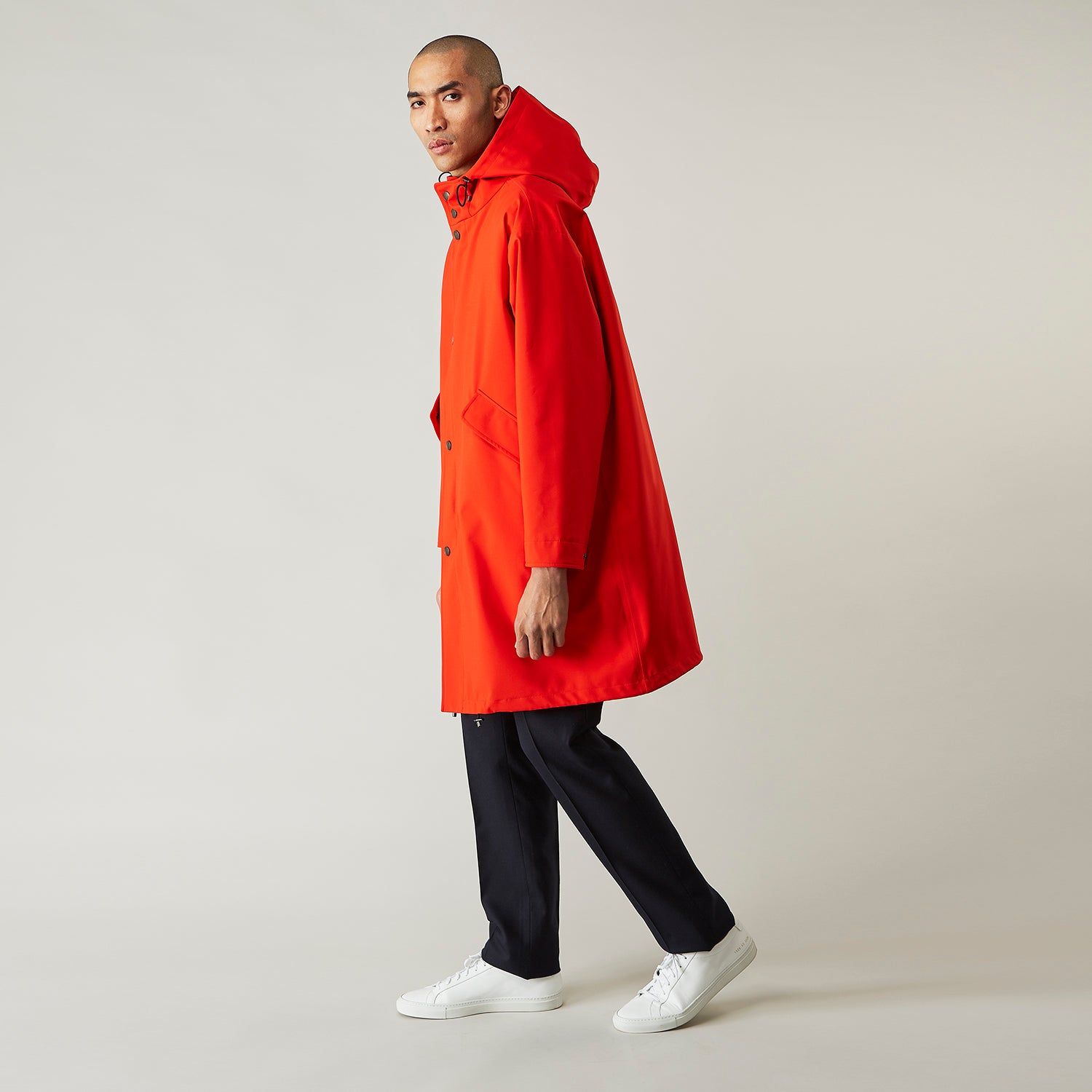 View 1 of product Wearing the Turnbull & Asser Red Walter Sealup Parka with Detachable Liner, black pants, and white sneakers, a person stands in profile against a plain light background—perfect for travel.