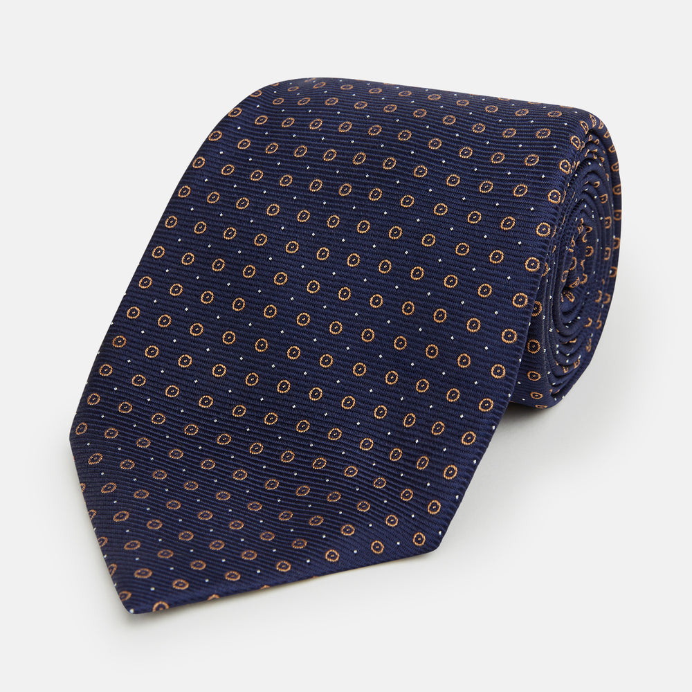 The Turnbull & Asser Navy and Brown Circle Silk Tie features an elegant pattern, perfect for adding a refined touch to your modern office attire.