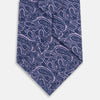 View 3 of product The Turnbull & Asser Lilac Paisley Silk Tie is shown rolled up, featuring a blue paisley pattern on a light purple background and displayed on a white surface.