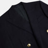 View 2 of product The Turnbull & Asser Short Navy Double Breasted Classic Blazer, featuring gold buttons, peaked lapels, and two front flap pockets, is displayed on a plain white background.