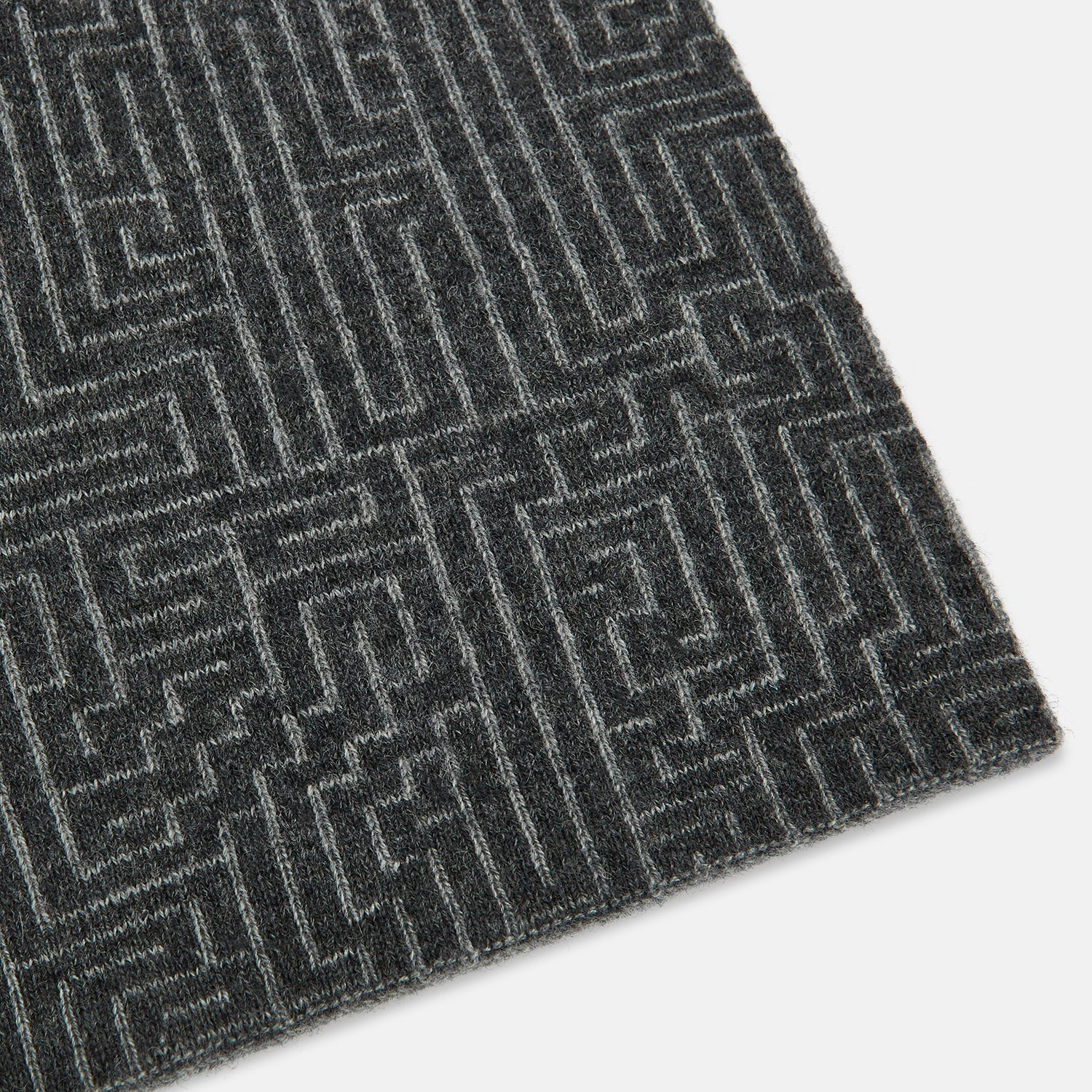 Image 2 of product The Turnbull & Asser Grey Fretwork Cashmere Knitted Scarf showcases a geometric maze-like pattern in gray, elegantly looped with draped ends—an essential accessory set against a plain white background.