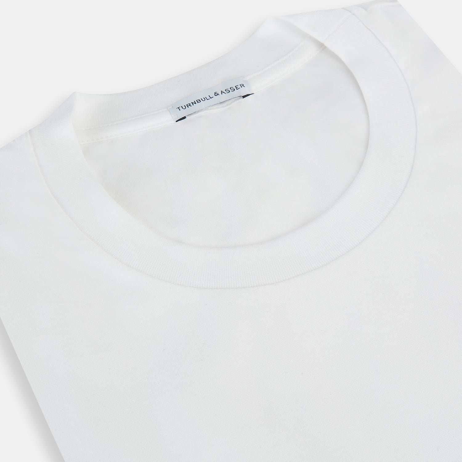 View 2 of product Experience comfort in the Turnbull & Asser White Short-sleeve Pyjama Shirt—a plain crew neck T-shirt laid flat on a white background, perfect as elevated loungewear or a sleek pyjama essential.