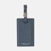 View 1 of product The Blue Leather Luggage Tag by Turnbull & Asser features textured leather, a metal buckle and strap, and displays the logo with "Made in England" printed in white at the bottom.