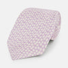 View 1 of product The Turnbull & Asser Lilac Flower-Patterned Printed Silk Tie, featuring a light lilac hue and small white circular designs, is shown rolled up against a plain white background.