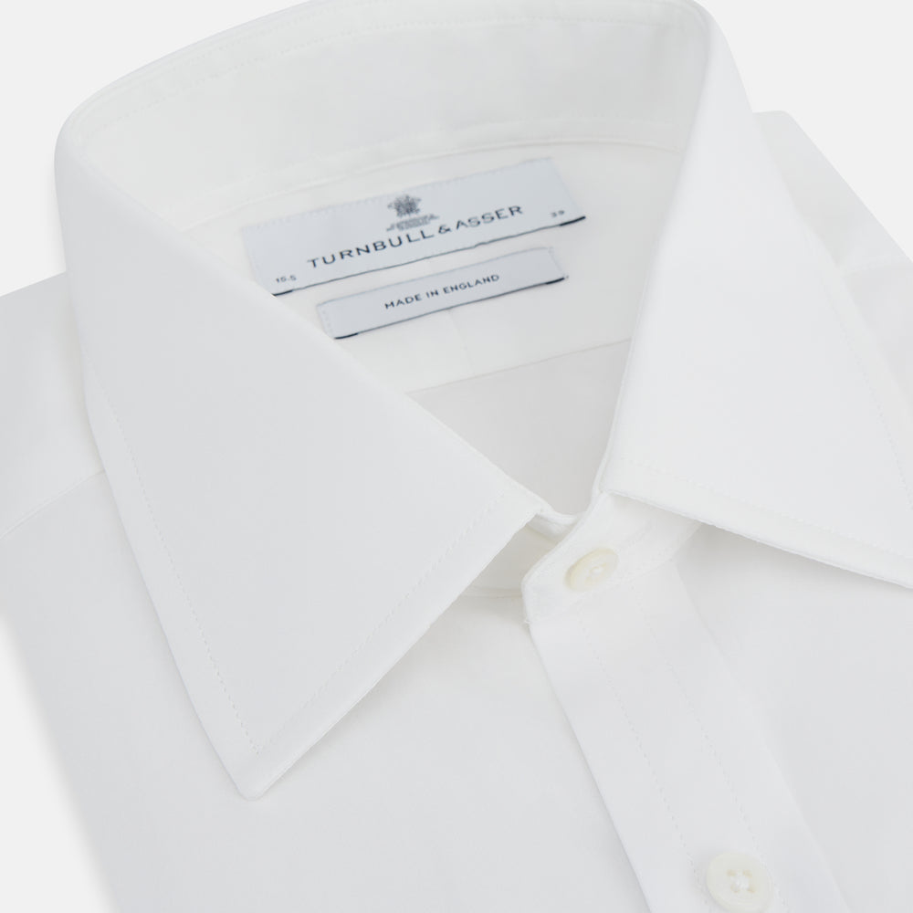 The Turnbull & Asser Plain White Cotton Shirt features a T&A collar and double cuffs, shown flat on a white background—ideal for pairing with standout ties or achieving a minimalist look.