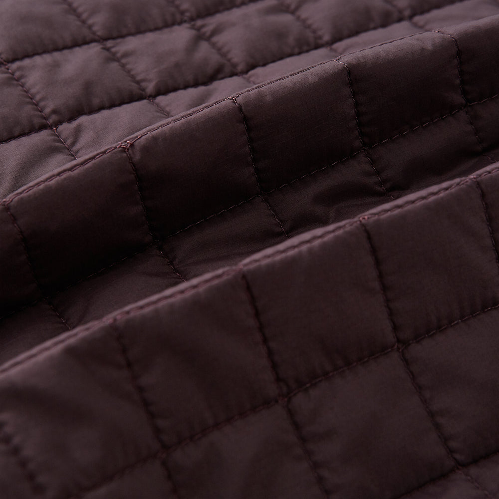 The Turnbull & Asser Burgundy Double-Breasted Quilted Gilet is a sleeveless vest with black buttons, an angled front, subtle check pattern, side and chest pockets—an ideal menswear piece for versatile layering.