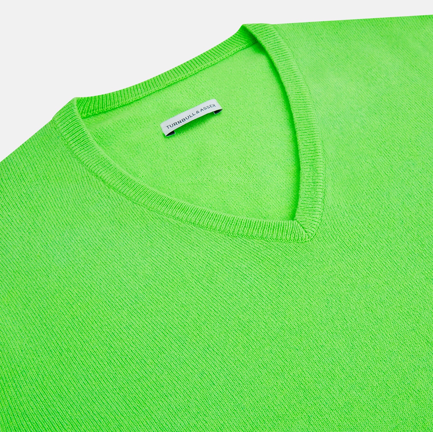 View 2 of product The Turnbull & Asser Bright Green Cashmere V-Neck Jumper features long sleeves with ribbed cuffs and hem—a vibrant addition to your knitwear collection, shown on a plain white background.