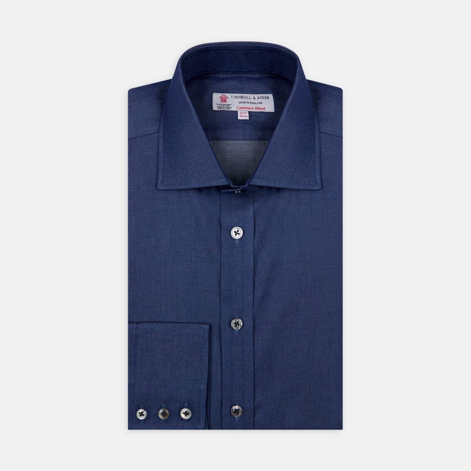 View 1 of product The Turnbull & Asser Dark Blue Denim-Cashmere Shirt features a Regent collar, long sleeves, and 3-button cuffs, neatly folded and displayed on a plain light background.