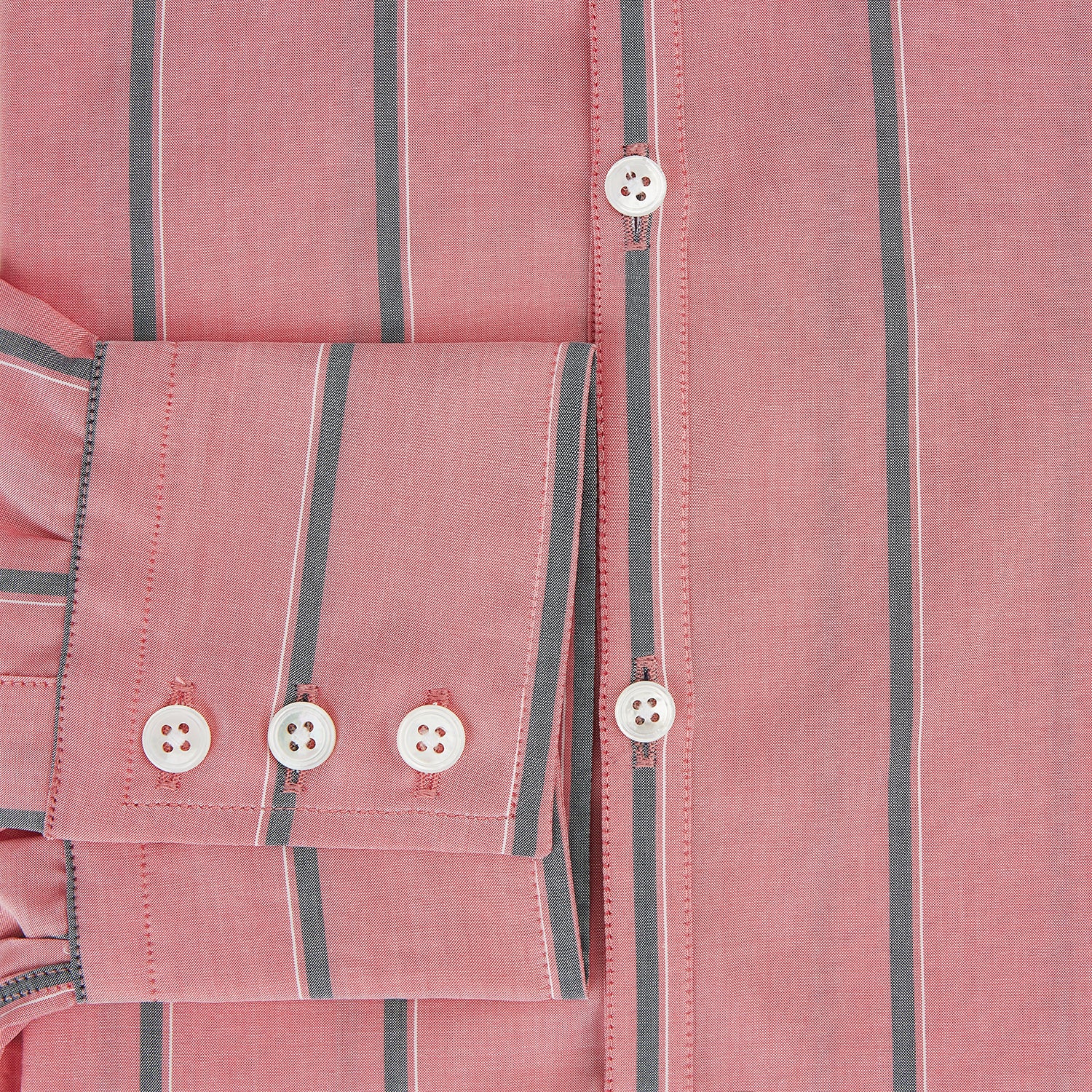 Image 4 of product The Coral Pink Track Stripe Westminster Shirt by Turnbull & Asser features vertical navy and white stripes, a tailored fit, pointed collar, and buttoned cuffs—is displayed laid flat on a white background.