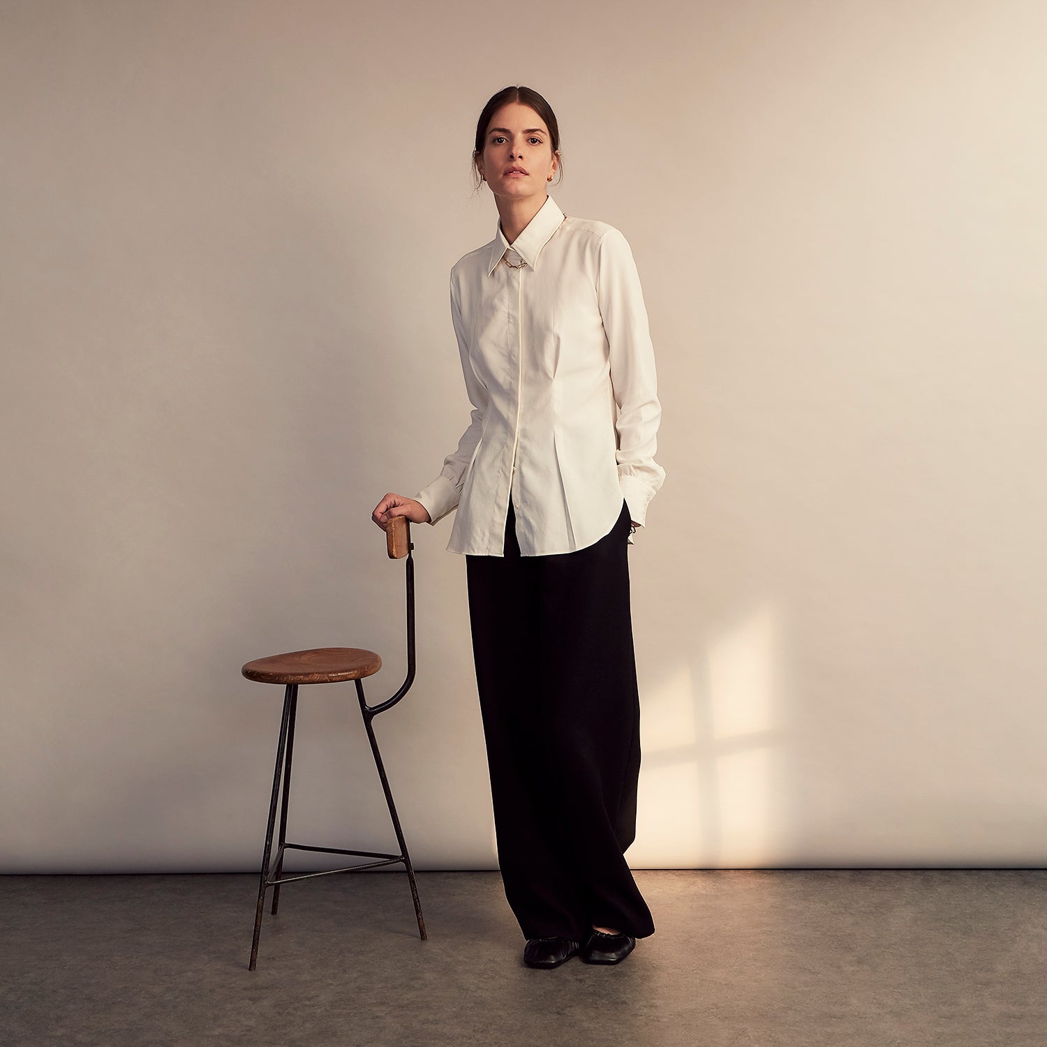 View 6 of product The Cream Silk Tailored Bianca Shirt by Turnbull & Asser features long sleeves, a pointed collar, and curved hem in soft-touch peace silk with a tailored fit. Shown laid flat on a white background.