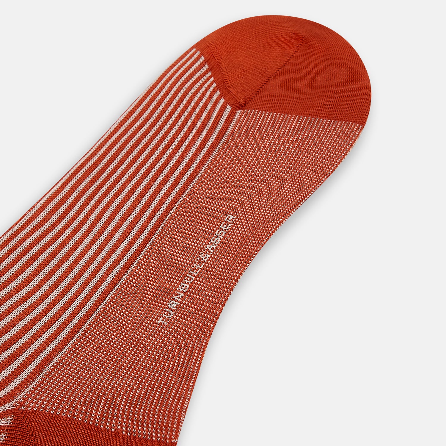 View 3 of product Turnbull & Asser's Rust/White Thin Striped Long Socks feature thin vertical stripes with a solid burnt orange cuff, heel, and toe. A single over-the-calf sock displayed on white background—ideal for those seeking stylish long socks.