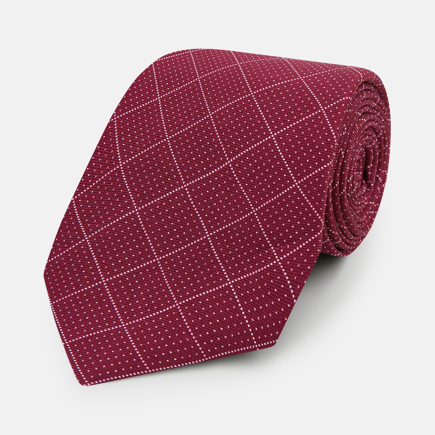 View 1 of product The Turnbull & Asser Burgundy Dotted Check Pattern Printed Silk Tie is shown rolled up on a plain white background.