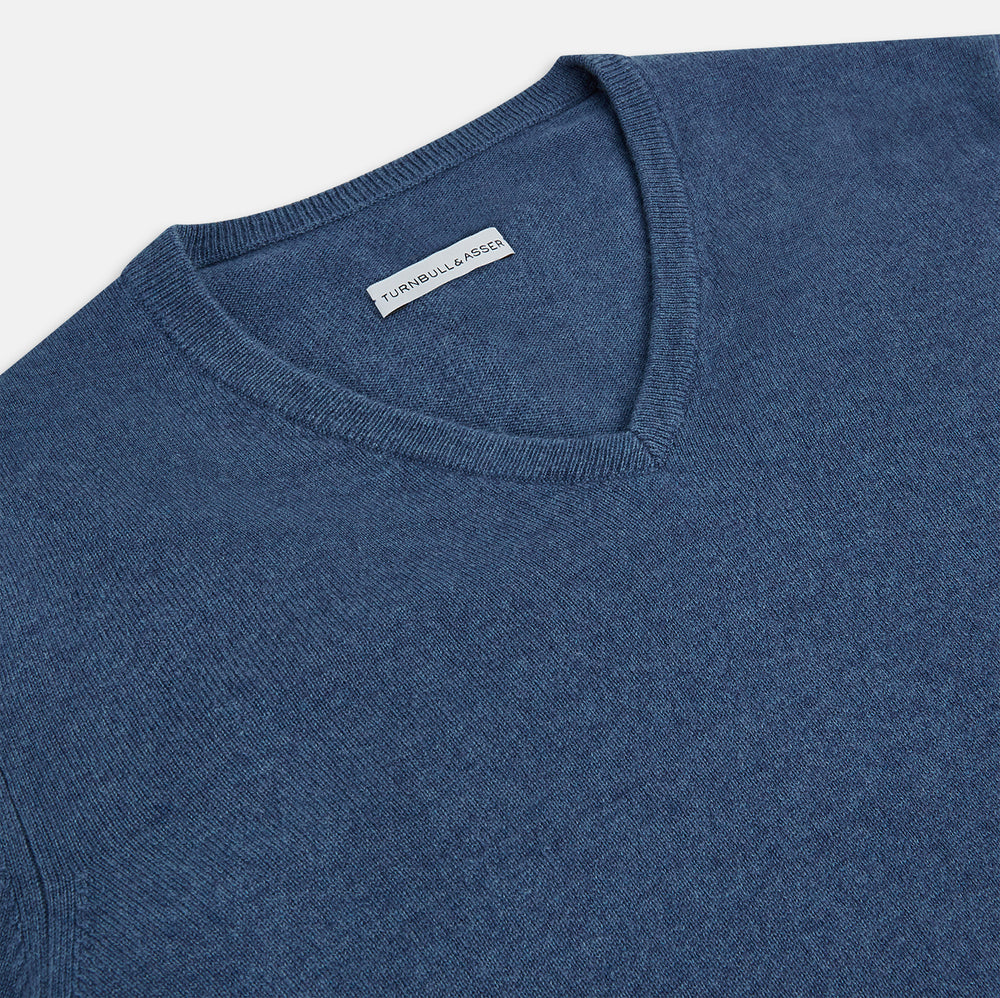 Turnbull & Asser’s Pacific Blue Cashmere V-Neck Jumper features ribbed cuffs, hem, and neckline, shown on a white background.