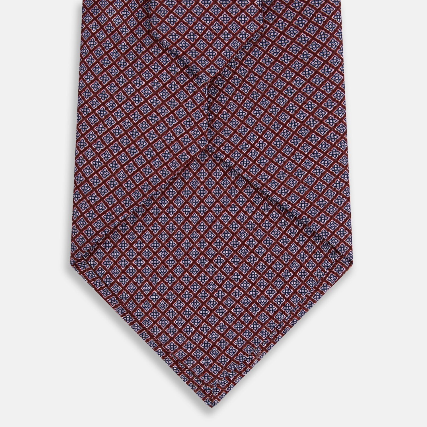 View 3 of product The Turnbull & Asser Indies Red Floral Square-Print Silk Tie is shown rolled up, highlighting its red floral square pattern against a plain white background.
