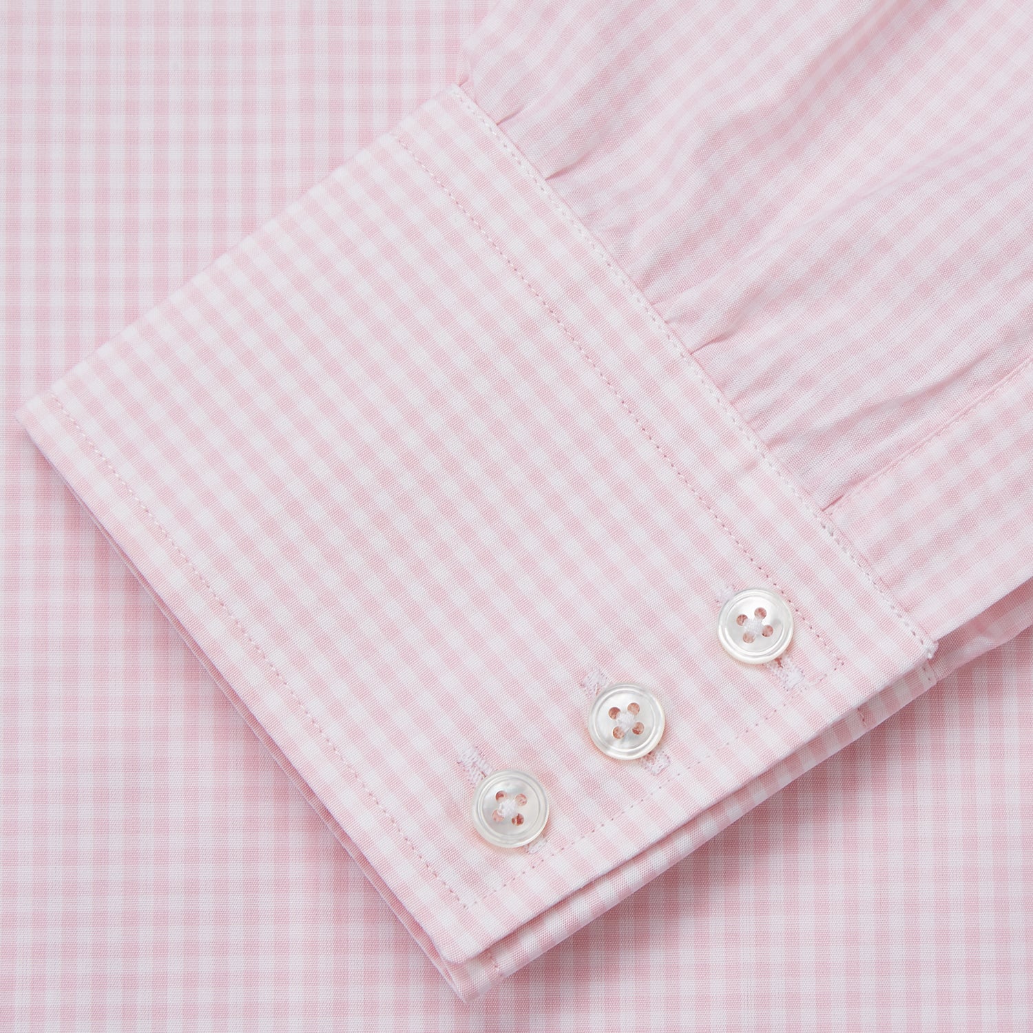 View 4 of product The Pink Windowpane Check Mayfair Shirt by Turnbull & Asser features a light pink, long-sleeve design with subtle windowpane checks, button-down front, and soft organic cotton, shown against a white background.