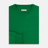 View 4 of product The Turnbull & Asser Grass Green Cashmere Round Neck Jumper features long sleeves, ribbed cuffs, collar, and hem, shown on a white background.