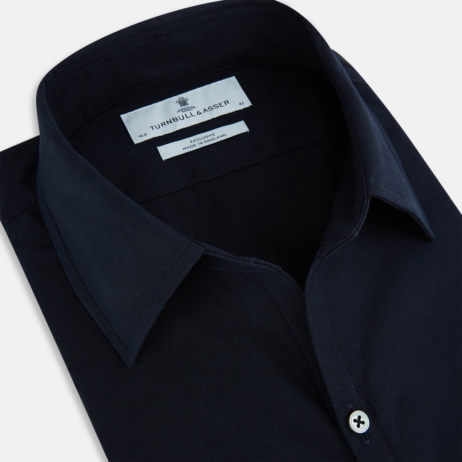 View 2 of product The NAVY BLUE WINDSOR SHIRT by Turnbull & Asser features long sleeves, a classic Windsor collar, white buttons, and buttoned cuffs—highlighting refined British craftsmanship against a plain white background.